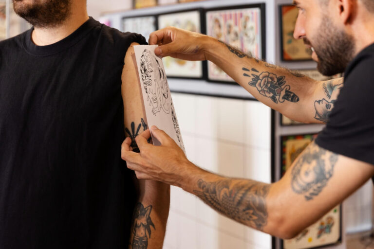 Side view of a man getting a tattoo knowing the less painful spots for tattoos